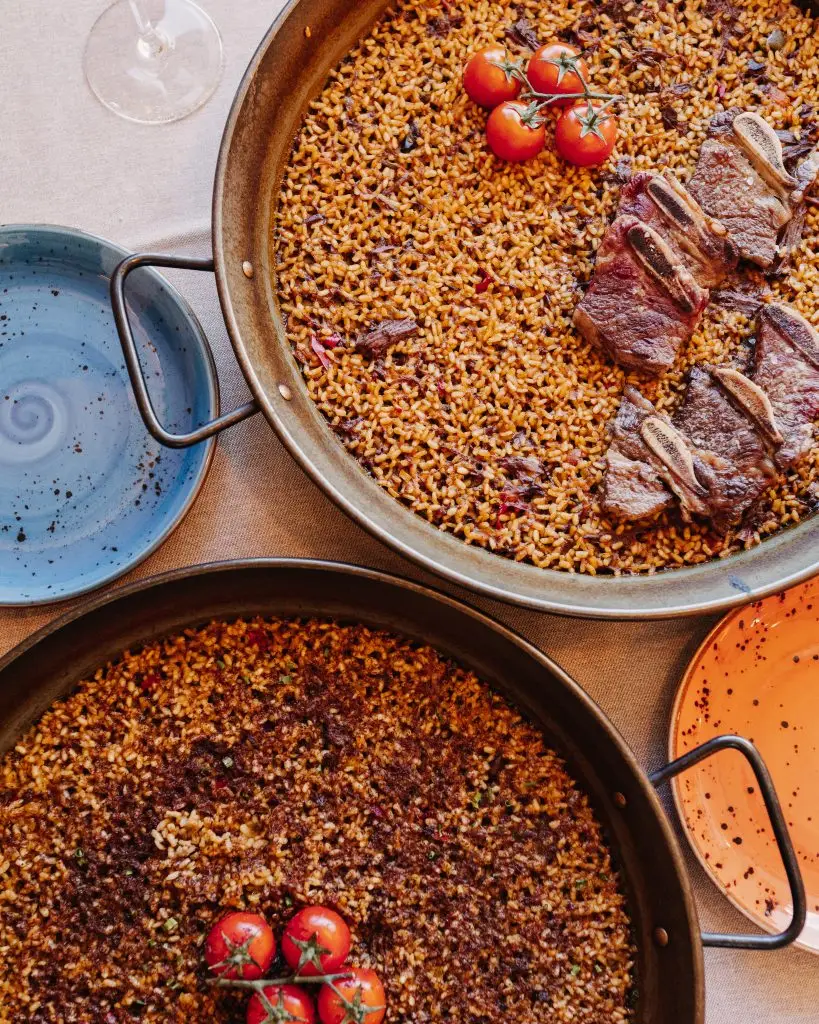 Dos paelleras con arroces de autor y tomates cherry en El Bejeque