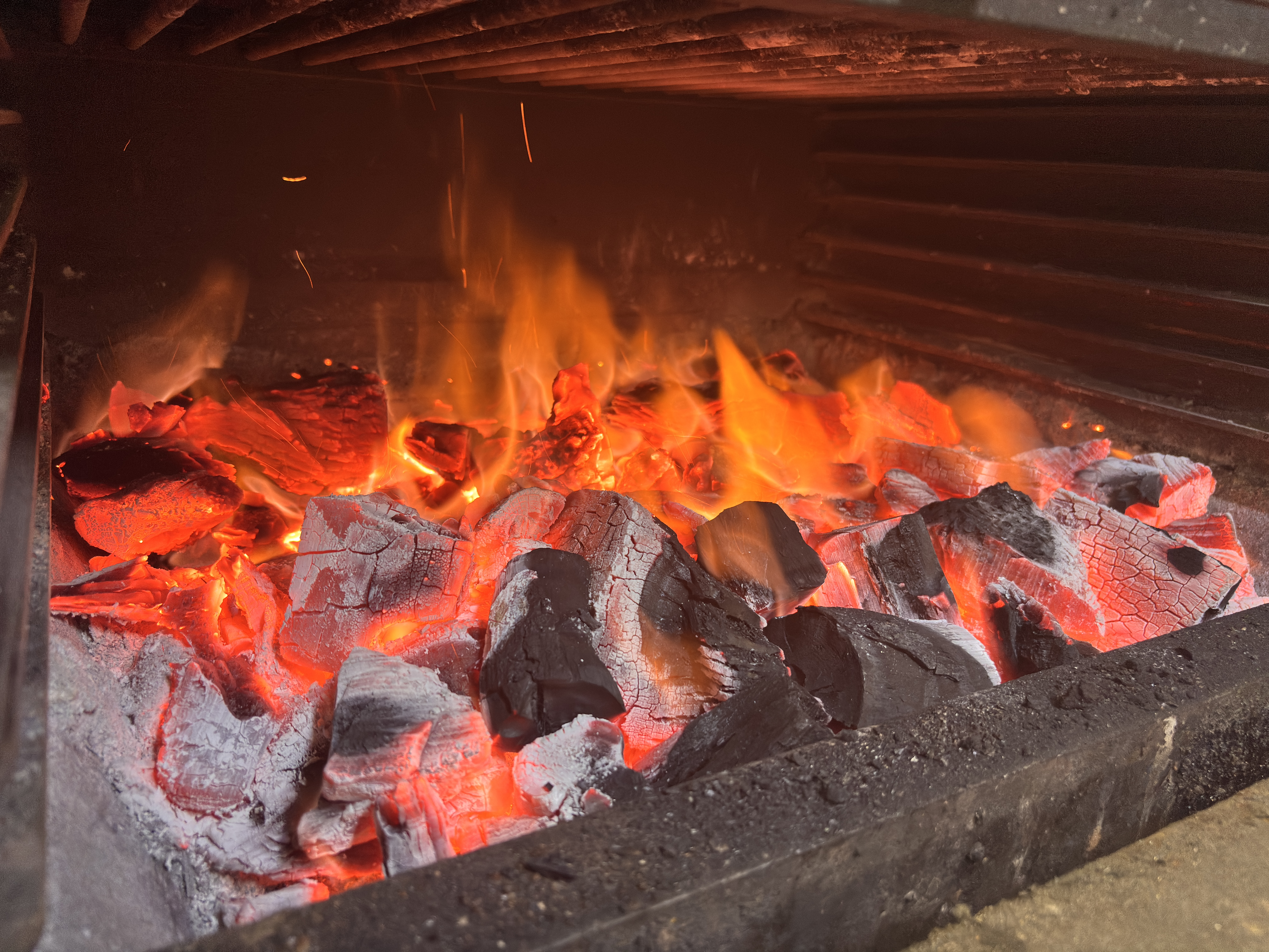 Brasas encendidas en el horno de El Bejeque con llama viva