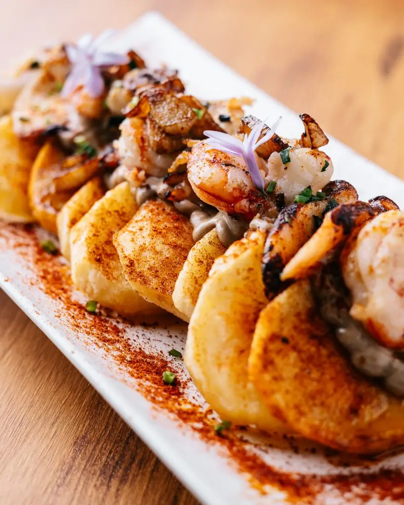 Entrante de vieiras selladas con gambas y flores comestibles