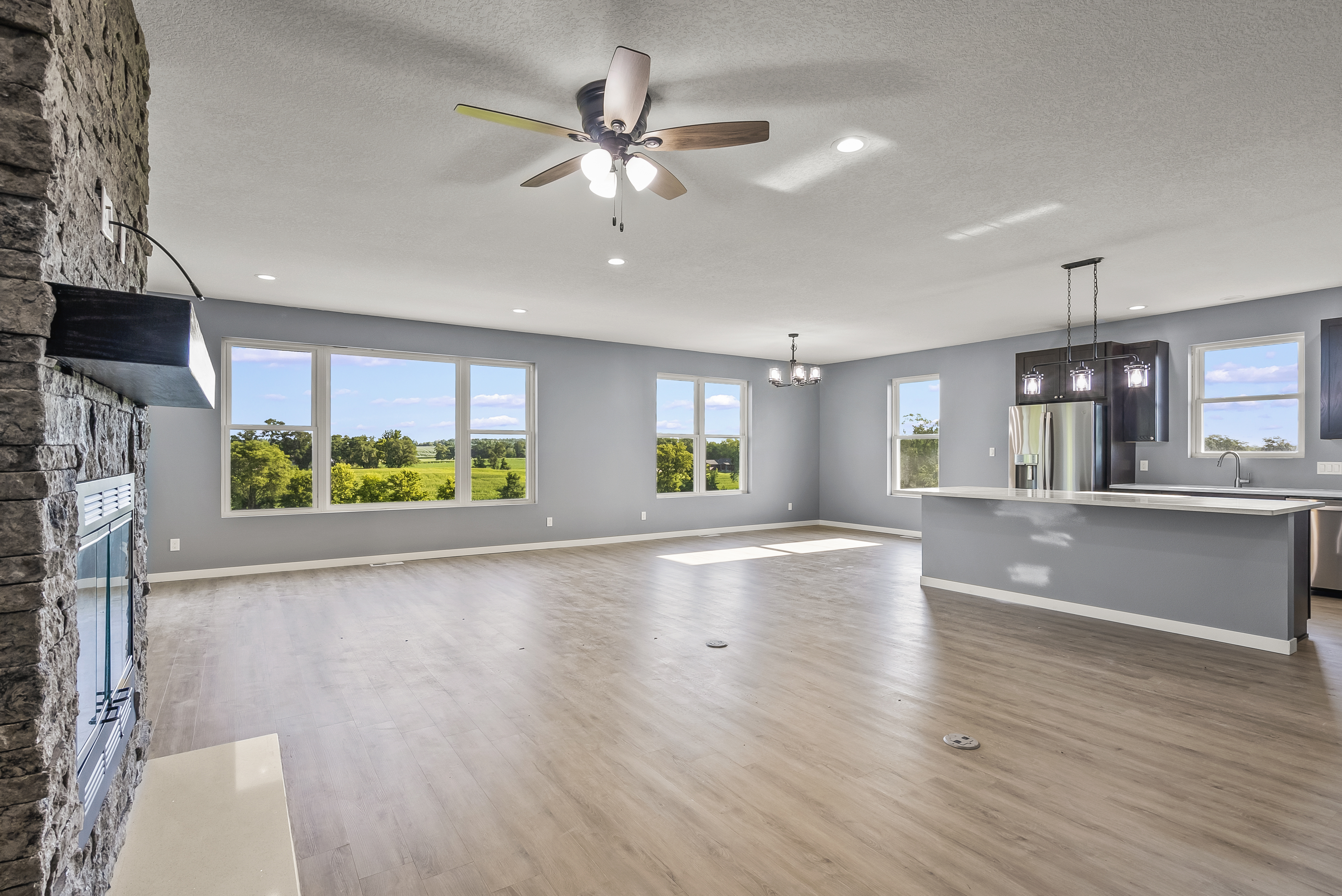 Open concept living room with stone fireplace and kitchen island built by Newhoff Construction