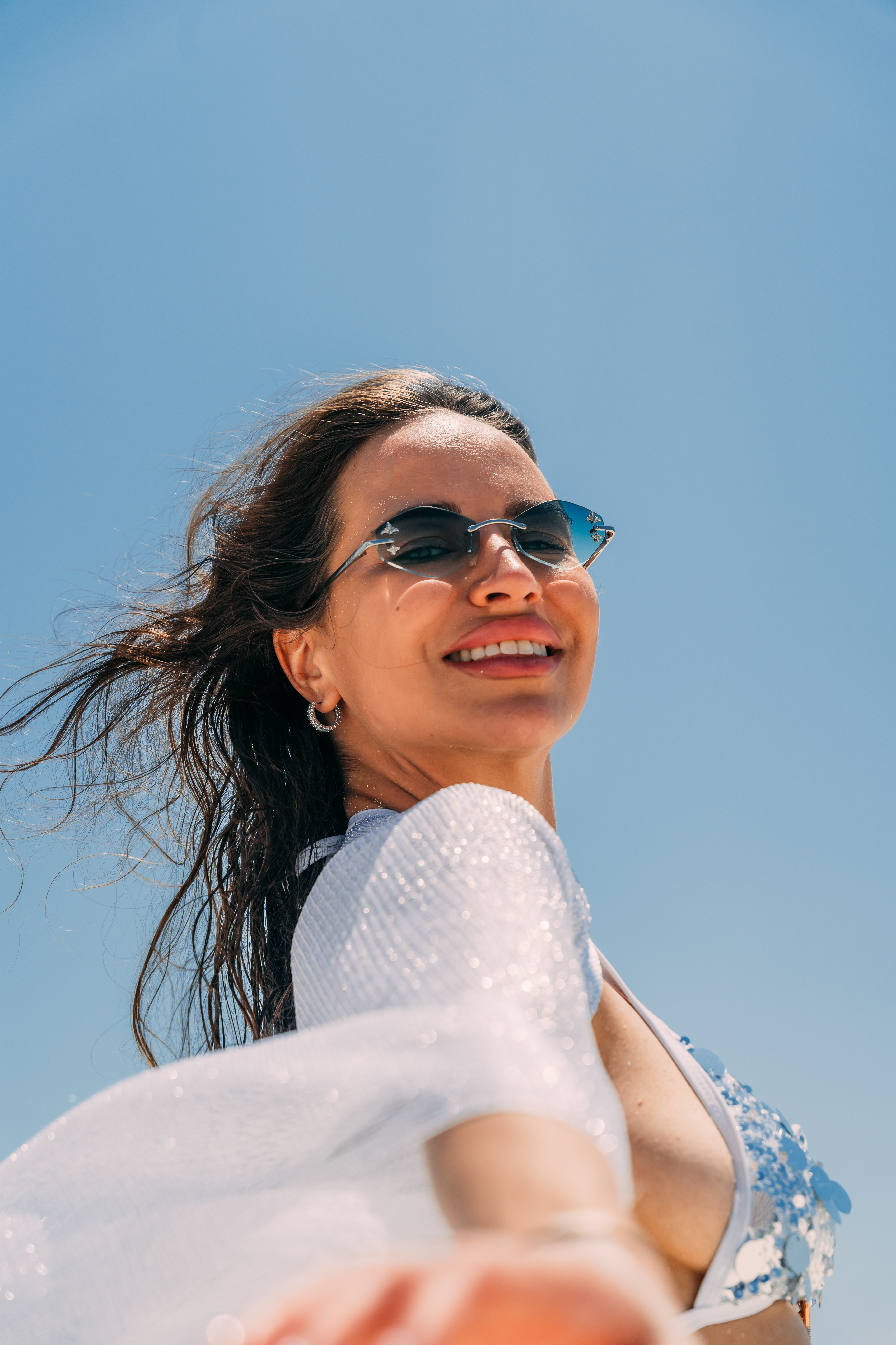 Woman smiling with sunglasses at Nungwi beach Zanzibar with blue sky background