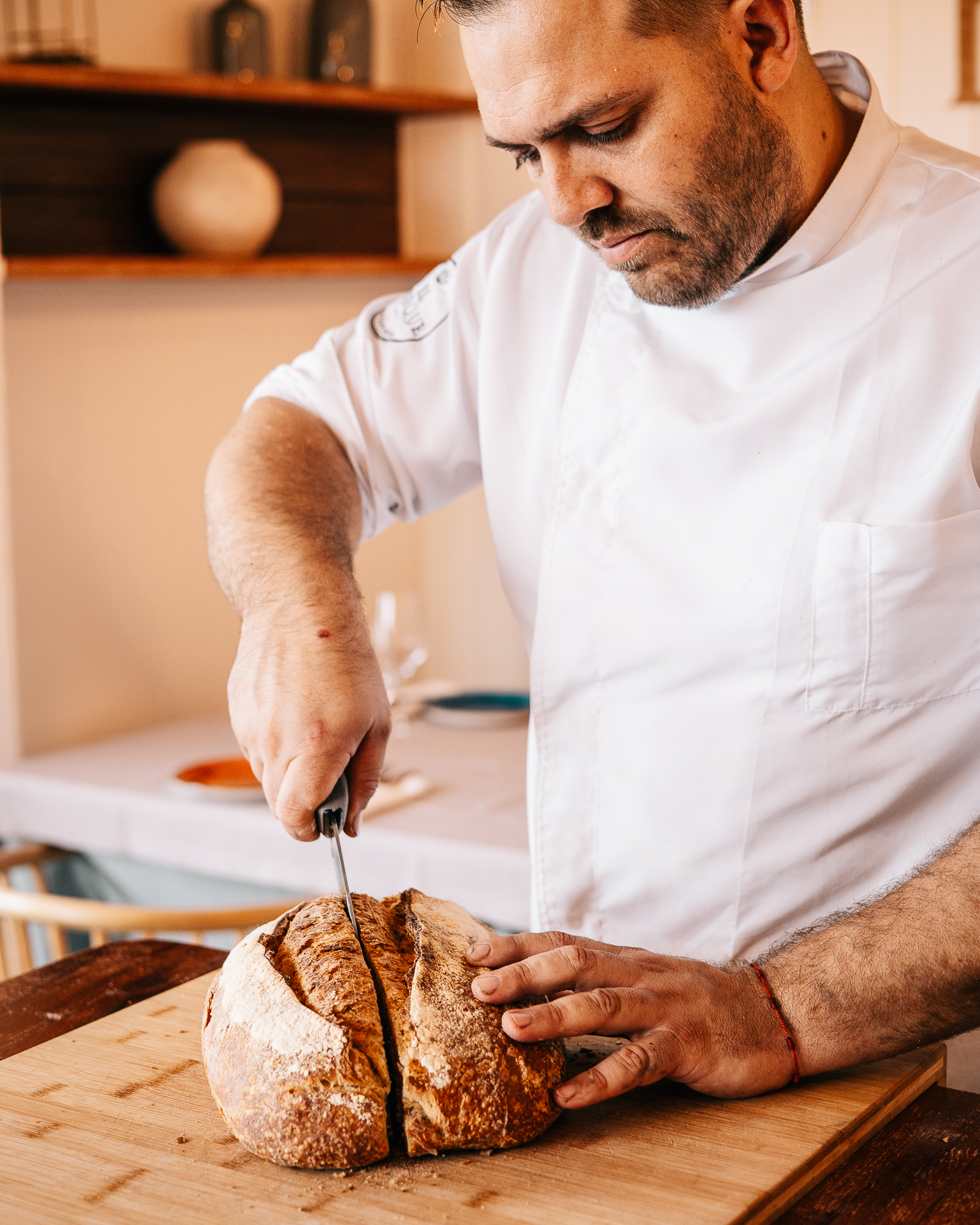 Chef Ayoze cortando pan artesano en tabla de madera