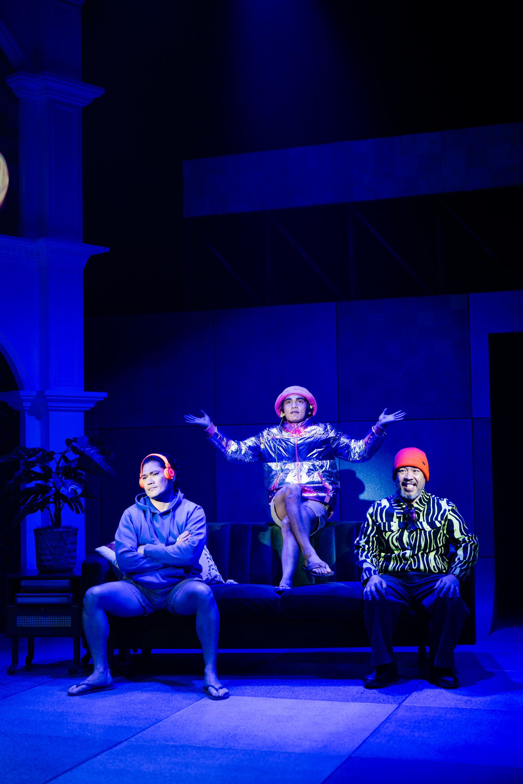 Marcus Rivera with cast members on couch under blue lighting in Malacañang Made Us, Queensland Theatre Company 2025. Photo by Morgan Roberts.